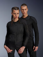 Man and woman wearing Alpinestars Troop-Air and Stella Troop-Air Jackets, black technical mesh motorcycle jackets, featuring 2D tech mesh structure for ventilation and reinforced panels, contemporary urban riding apparel.