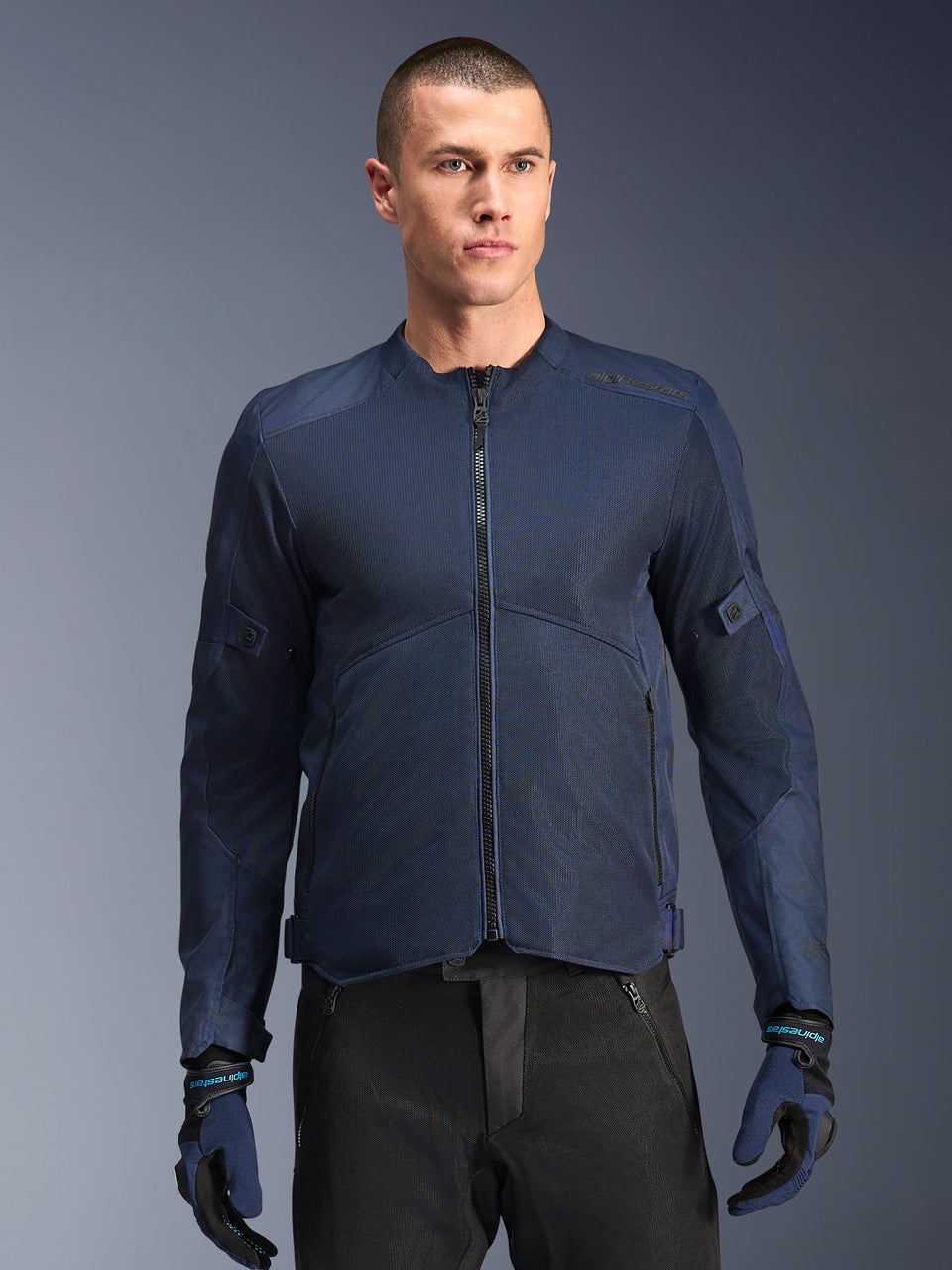 Alpinestars C-1 Air Jacket, Blue motorcycle jacket, worn by a male model with black pants and matching blue and black gloves, featuring tech mesh panels for airflow, clean urban design with front zipper and subtle branding