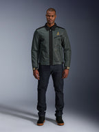 Alpinestars Ignite Air Jacke in Urban Gray Black Blue, Motorradjacke im Harrington-Stil mit Hemdkragen und Mesh-Konstruktion, getragen von einem Mann mit dunklen Denim-Jeans und schwarzen Sneakern, urbane Streetwear für Fahrer.