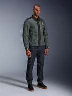 Alpinestars Ignite Air Jacke, Urban Gray Black Blue, urbane Motorradjacke, getragen von einem Model mit dunkler Denim-Jeans und schwarzen Sneakern, mit Mesh-Hauptteil, traditionellem Hemdkragen, Harrington-inspirierter Silhouette und goldenem Alpinestars-Branding.