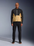 Alpinestars Provoke Jacke in Black Camel, urbane Motorradjacke mit zweifarbigem Design in Schwarz und Camel, getragen von einem Model mit schwarzer Hose und schwarzen Schuhen, moderne Silhouette mit weißen Reißverschlüssen und technischer Softshell-Konstruktion.