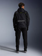 Alpinestars Mogress Air Jacke, urbane Motorradjacke, Rückansicht in Schwarz mit Lime Punch und weißen Akzenten, mit Alpinestars-Branding am unteren Rücken, getragen mit schwarzer Hose und Stiefeln.