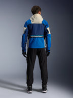 Alpinestars Mogress Air Jacket in Blue Almond, back view of a rider wearing the motorcycle jacket, featuring navy and bright blue panels with an off-white hood, bold Alpinestars branding on the lower back, urban contemporary riding gear style.