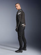 Alpinestars T-Stunt Air Jacke, Schwarz und Weiß, modulare Motorradjacke mit Tech-Mesh-Einsätzen, Rückansicht im Profil an einem Modell, getragen mit schwarzer Fahrhose und Schuhen, mit weißen Akzenten und Branding auf den Schultern und dem Rücken.