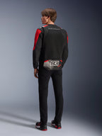 Model from behind wearing the Alpinestars MM93 T-SPS Air V2 Jacket, Black with Bright Red and White details, featuring 'MARC MARQUEZ' text and large '93' logo on the back tail, mesh textile construction for ventilation, worn with black pants and coordinated black and red riding shoes