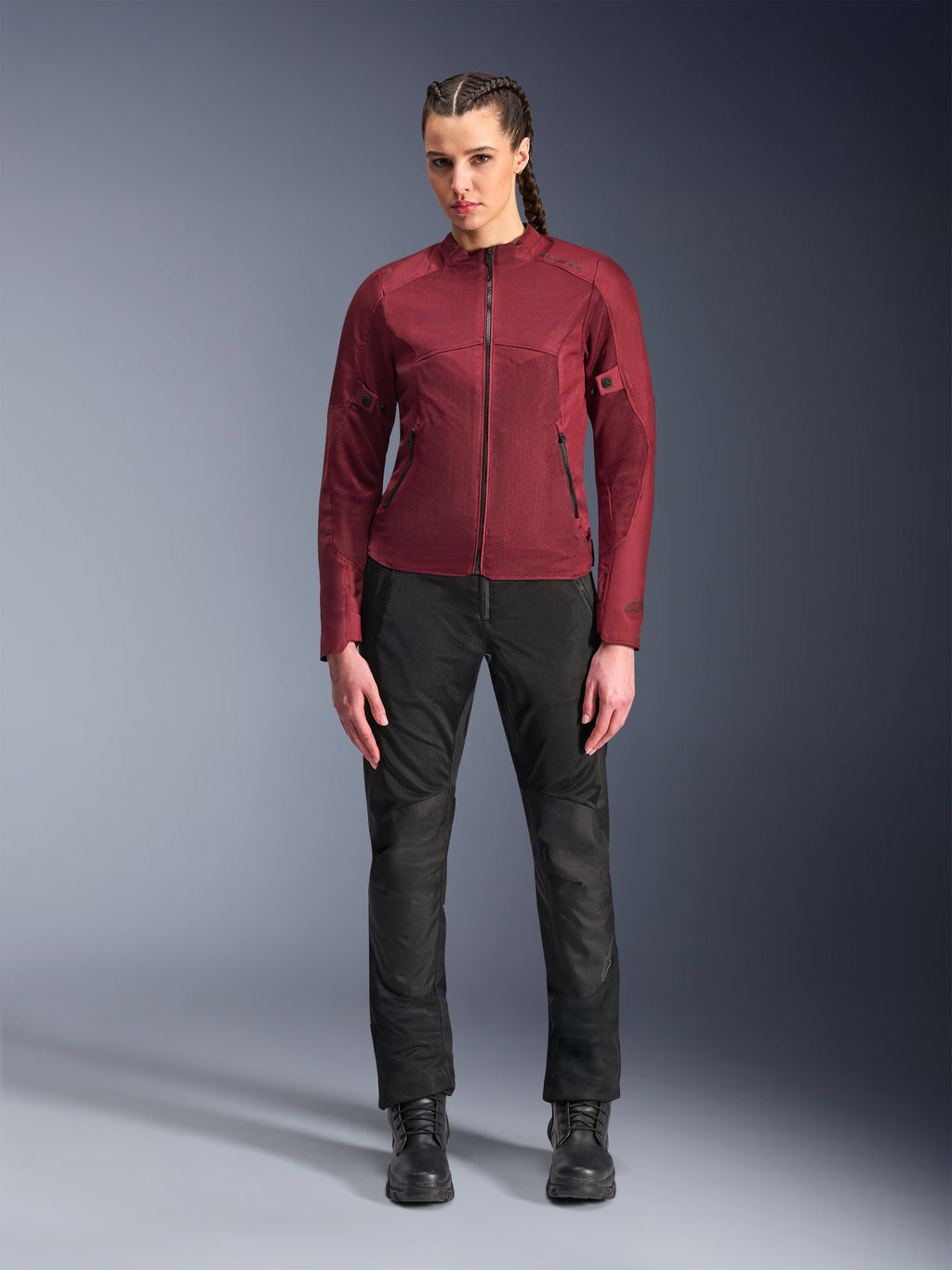 Alpinestars Stella C-1 Air Jacke für Damen, burgunderrote Textil-Motorradjacke mit Mesh-Einsätzen zur Belüftung und Reißverschlusstaschen, getragen von einem Modell mit schwarzer Motorradhose und Stiefeln, moderne urbane Motorradbekleidung für Damen
