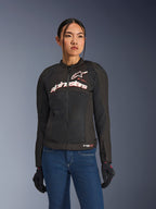Woman wearing Alpinestars Stella SMX Air Jacket, Black White Red Fluo, textile motorcycle jacket with ventilated mesh and white chest logo, styled with blue jeans and black riding gloves, feminine fit for sport riding