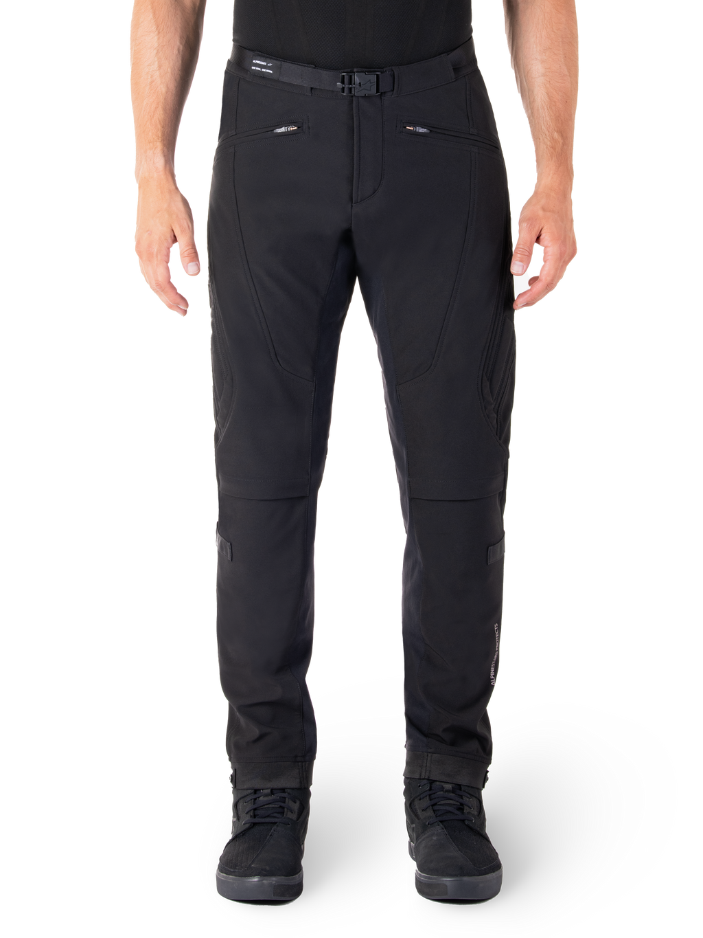 Alpinestars Alden Hose, Schwarze Urban-Motorradhose, Vorderansicht, technisches Stretch-Softshell-Gewebe, integrierter Gürtel mit Magnetschnalle, Reißverschlusstaschen vorne, gesteppte Knie-Details, Slim-Fit-Silhouette, kombiniert mit schwarzen Motorradschuhen
