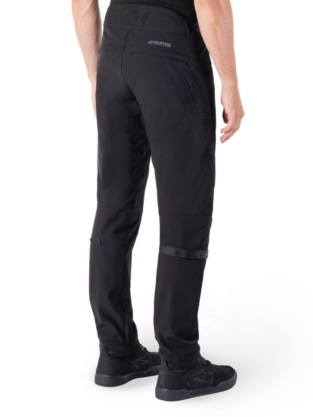 Alpinestars Alden Hose, Urbane Motorradhose, Schwarz, Rückansicht mit technischem Softshell-Gewebe und gesteppten Details, reflektierendes MO.ST.EQ.-Branding auf der Rückenpasse und verstellbare Wadengurte, kombiniert mit schwarzen Motorradschuhen