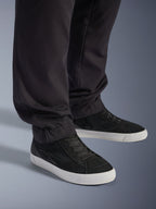 Alpinestars Flex-AST Cargo Pants - Short, Urban Motorcycle Pants, Black, featuring tapered legs with elasticated hems, paired with black Alpinestars sneakers, contemporary urban riding style