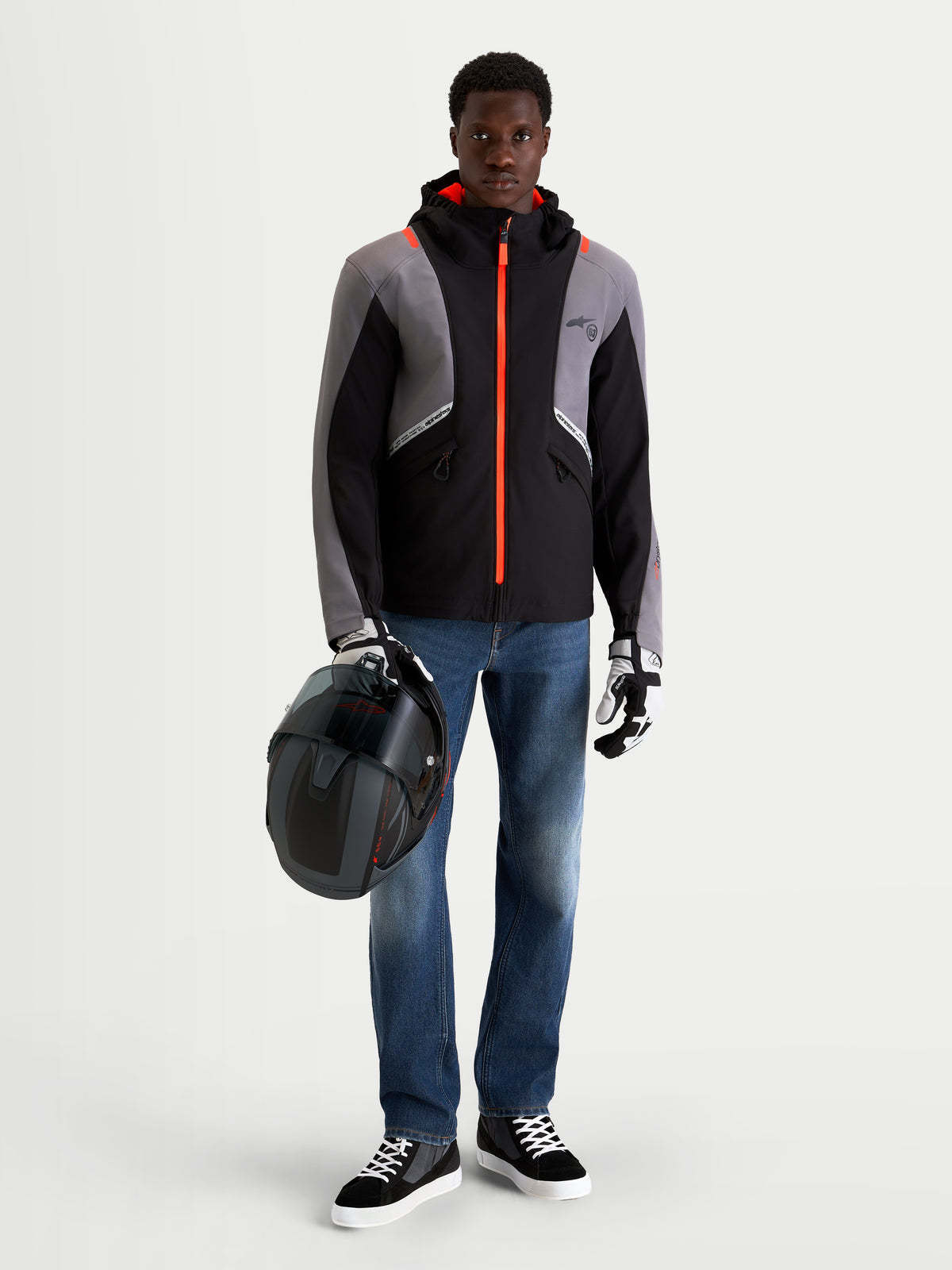 Alpinestars Flex-AST 8 Denim Pants, men's urban contemporary motorcycle riding jeans in medium blue, worn by a model holding a helmet and wearing a black and gray technical jacket