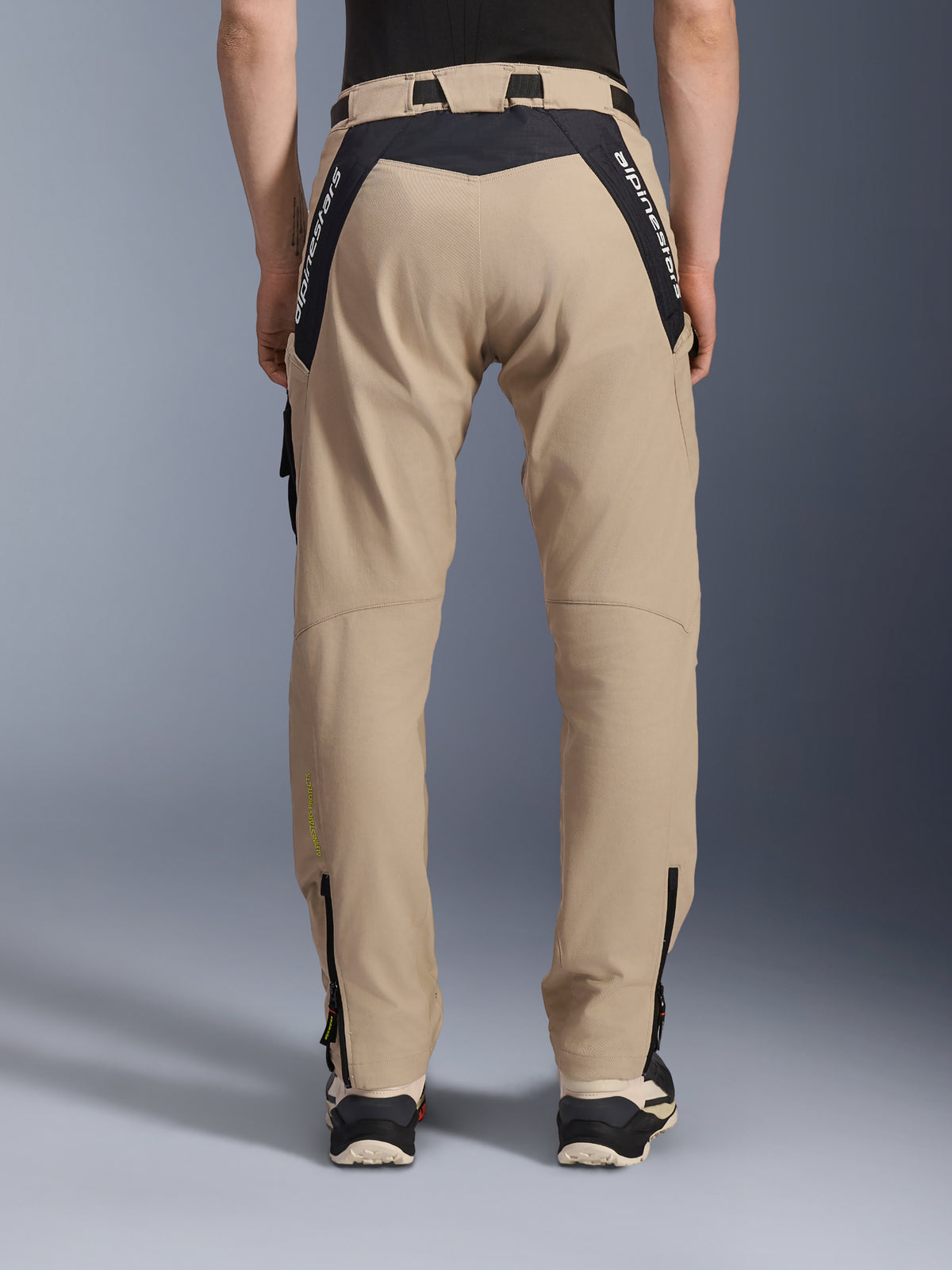Alpinestars Acteon Hose, Urban-Motorradhose, Sand, Rückansicht mit schwarzen Ripstop-Einsätzen und weißem Branding am Sattel, schmal zulaufende Passform mit Reißverschlüssen an den Beinabschlüssen, moderne Straßenausrüstung