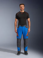 Alpinestars Maxdura Dual Pants, Adventure Motorcycle Pants, Royal Blue and Deep Gray, orange zipper accents, worn with a black Alpinestars base layer and black boots, featuring reinforced knee panels and a technical off-road design