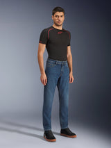 Alpinestars Flex-AST 5 Denim-Hose, Motorradjeans in Indigo Washed, moderne konische Passform, getragen von einem männlichen Model mit einem schwarzen Performance-T-Shirt und schwarzen Sneakern, lässige urbane Motorradbekleidung