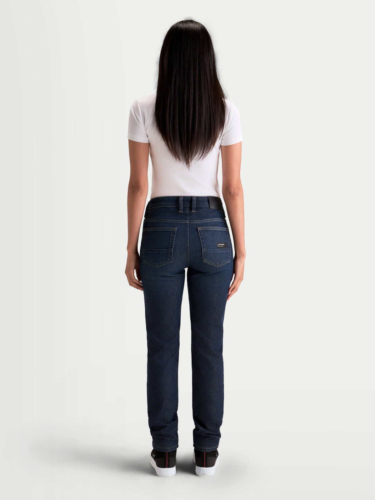 Alpinestars Stella Flex-AST 7 Denim Pants, women's motorcycle riding jeans in dark blue, rear view on a model wearing a white t-shirt, showing the five-pocket construction, leather back patch, and back pocket embroidered logo