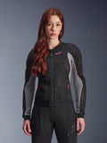 Alpinestars Woman Stella Troop-Air Jacket, Women's Motorcycle Mesh Jacket, Black Ash Gray and Pink Fluo, worn by a model with matching riding pants, featuring ventilated 2D tech mesh construction and pink logo detail, designed for urban summer riding.