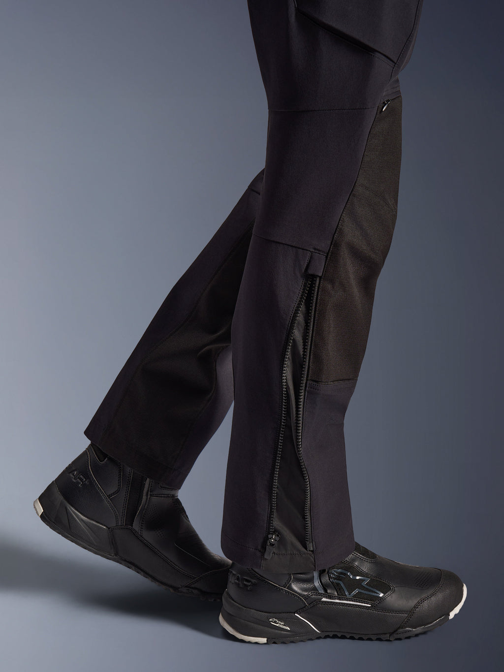 Alpinestars Stella Flex-AST Explorer Hose, Damen-Motorradhose, Schwarz, Nahaufnahme der Unterschenkel mit Reißverschlüssen an den Beinabschlüssen und strapazierfähigen Ripstop-Verstärkungen, getragen mit schwarzen Alpinestars Motorradschuhen