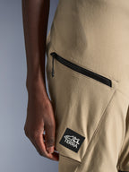 Alpinestars Stella Flex-AST Explorer Pants, Women's Motorcycle Pants, Sand, close-up detail of zippered cargo pocket and black ALL TERRA logo patch, durable ripstop textile construction for adventure touring
