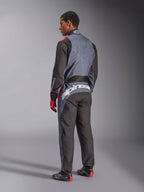 Rückansicht eines Models im Alpinestars KMX-9 V3 Graphic 6 Anzug, Kart-Anzug, Anthrazit Schwarz Rot, mit markantem weißem Alpinestars-Branding am unteren Rücken, schwarz-graues Paneel-Design mit roten Akzenten, kombiniert mit passenden Rennhandschuhen und Schuhen.
