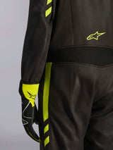 Alpinestars GP Race V3 Suit FIA, Black and Yellow Fluo, close-up detail of the waist and side leg, featuring aramidic stretch panels and matching racing glove, professional auto racing gear
