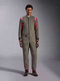 Alpinestars GP Race V3 Anzug FIA, Auto-Rennanzug, Anthrazit-Rot, getragen von einem männlichen Model mit passenden Handschuhen und Stiefeln, mit roten Schulter-Epauletten und Branding, professionelle Motorsportausrüstung für Performance-Fahren.