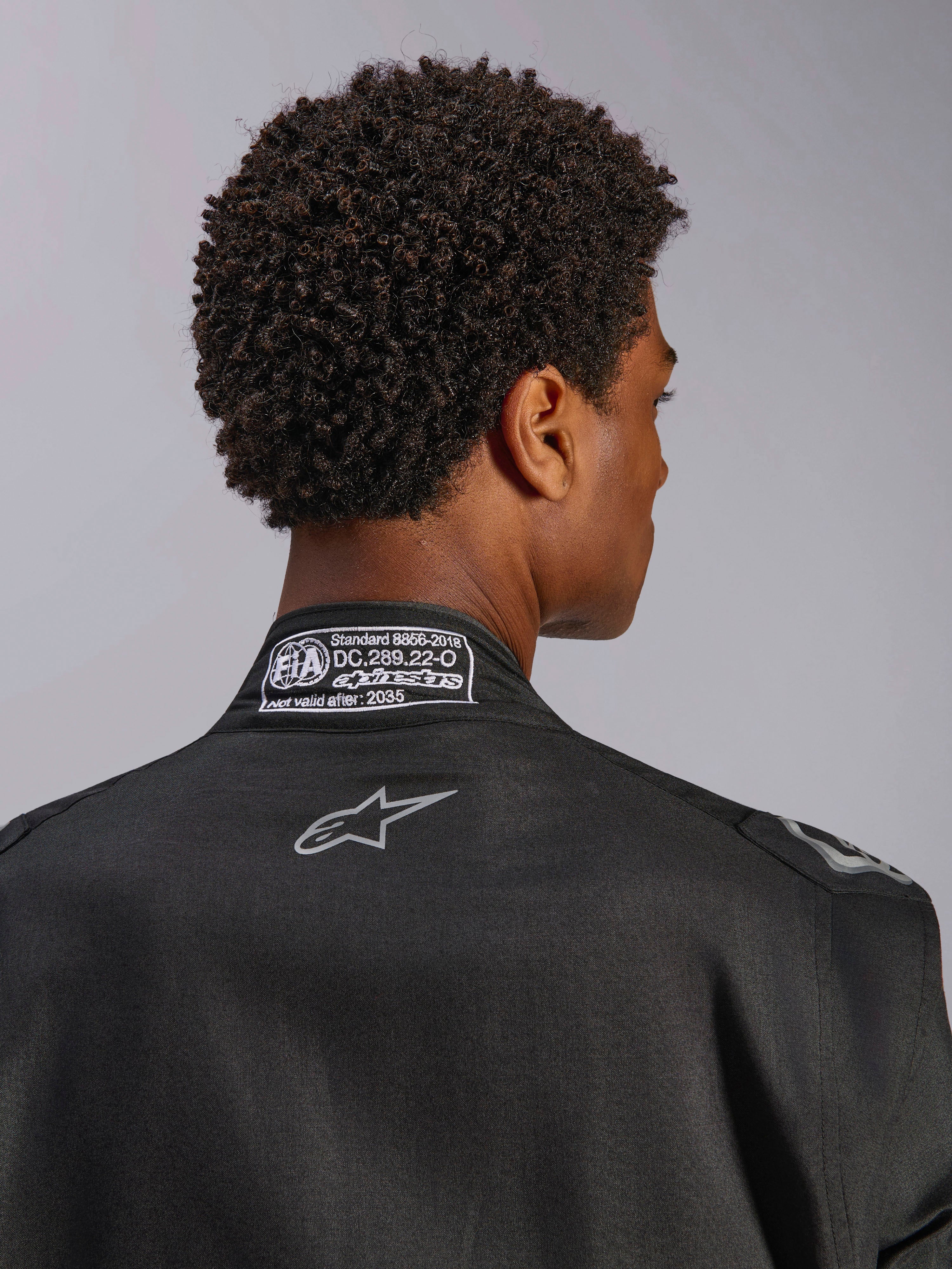 Alpinestars Hypertech V3 Anzug, Black Dark Shadow, Nahaufnahme der Rückansicht des Kragens mit FIA 8856-2018 Zertifizierungsetikett und Rücken-Logo, professioneller leichter Rennanzug mit athletischer Passform