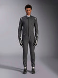 Alpinestars Hypertech V3 Anzug, professioneller Rennanzug, Schwarz und Dark Shadow, getragen von einem Model mit passenden Rennhandschuhen und Schuhen, athletische Passform mit silbernen Akzenten und Branding, Performance-Motorsportausrüstung