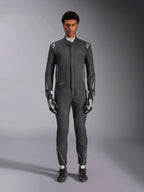 Alpinestars Hypertech V3 Anzug, professioneller Rennanzug, Schwarz und Dark Shadow, getragen von einem Model mit passenden Rennhandschuhen und Schuhen, athletische Passform mit silbernen Akzenten und Branding, Performance-Motorsportausrüstung