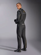 Alpinestars Limited Edition Lamborghini GP Tech V4 Anzug, professioneller Rennanzug, Schwarz mit silbernen und goldenen Akzenten, Rückansicht mit Lamborghini Squadra Corse und Alpinestars Branding, getragen mit schwarzen Rennhandschuhen und Rennschuhen, elegantes Motorsport-Design