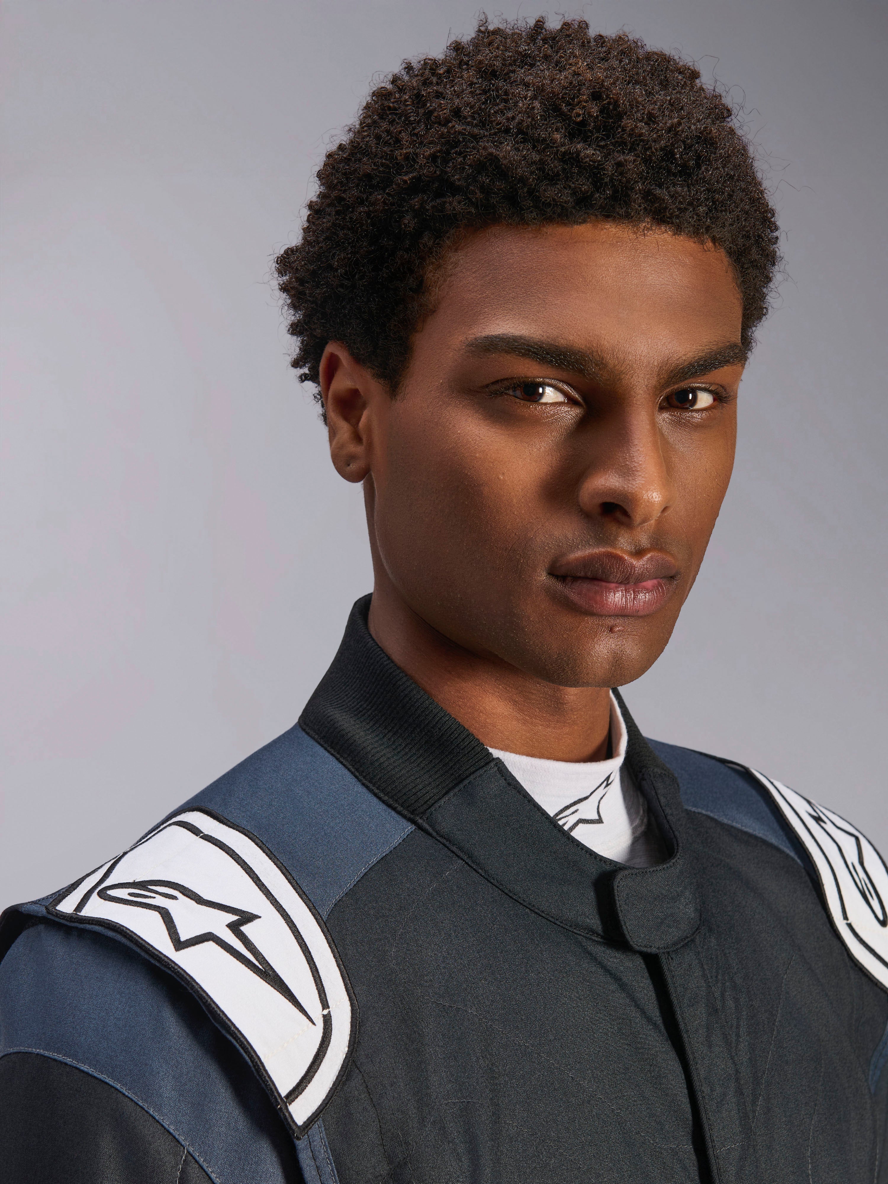 Alpinestars GP Pro Comp V2 FIA Suit, men's auto racing gear in Black and Asphalt with white logo shoulder epaulettes.
