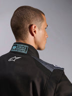 Alpinestars KMX-5 V3 Anzug in Schwarz und Dark Shadow, Nahaufnahme von Rücken und Kragen mit weißem Astars-Logo, FIA 8877-2022 Grade 1 Zertifizierungsetikett und belüfteten Mesh-Schultereinsätzen.