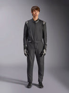 Alpinestars GP Tech V4 Anzug, Schwarz und Weiß, professioneller einteiliger Autorennanzug, getragen mit passenden schwarz-weißen Handschuhen und Rennschuhen, mit weißen Alpinestars-Logos an Schultern und Kragen, schlanke sportliche Passform für Motorsport-Wettbewerbe