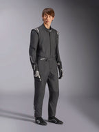 Alpinestars GP Tech V4 Anzug, einteiliger Autorennanzug, Schwarz und Weiß, getragen mit passenden Rennhandschuhen und Schuhen, mit weißen Logos auf den Schultern und Unterarmen, elegantes professionelles Design für den Motorsport