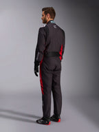 Alpinestars KMX-9 V3 Graphic 3 Anzug, Schwarz und Rot, Rückansicht eines Models in kompletter Karting-Ausrüstung einschließlich schwarzer Handschuhe und Rennstiefel, mit roten Seiteneinsätzen und weißen Logo-Details