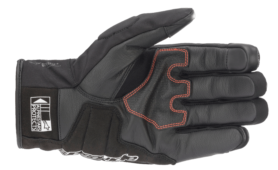 Displayed is the SMX Z Drystar® Glove by Alpinestars EU in a striking black and red fluo color combination. It features hard knuckle protectors, a Velcro wrist strap for secure fitting, and detailed stitching. This glove offers 100% waterproof protection, with extra padding on the index and middle fingers.