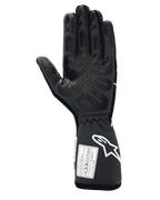 Alpinestars Tech-1 Race V4 Handschuhe, Professionelle Autorennhandschuhe, Schwarz Teergrau, Ansicht der Innenhand mit umfassenden Silikon-Gripmustern auf Fingern und Handfläche, verlängerte Stulpe mit weißem Alpinestars-Logo und FIA/SFI-Zertifizierungsetiketten