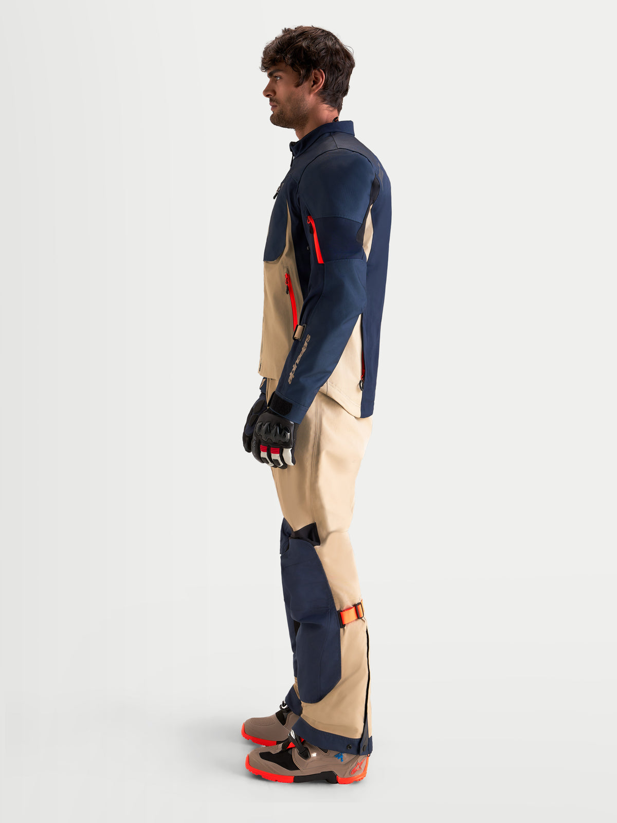 Alpinestars Arenis Gore-Tex Gear Set, men's adventure touring motorcycle textile jacket and pants in night navy and aluminum, side profile view worn by a model with matching gloves and boots, AA certified waterproof all-terrain riding apparel.