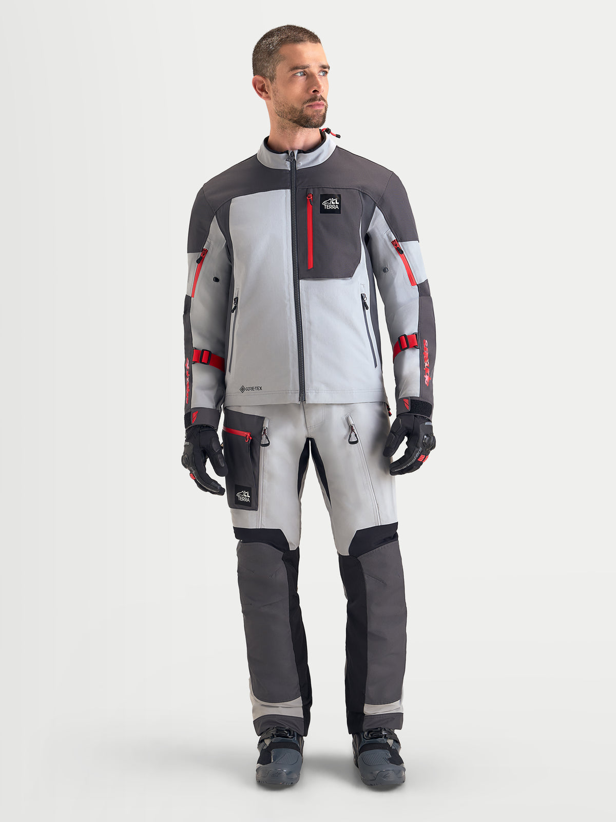 Alpinestars Arenis Gore-Tex® Jacket, men's adventure touring motorcycle jacket in mid gray, deep gray, and black, front studio view showing waterproof textile construction and red zipper details.