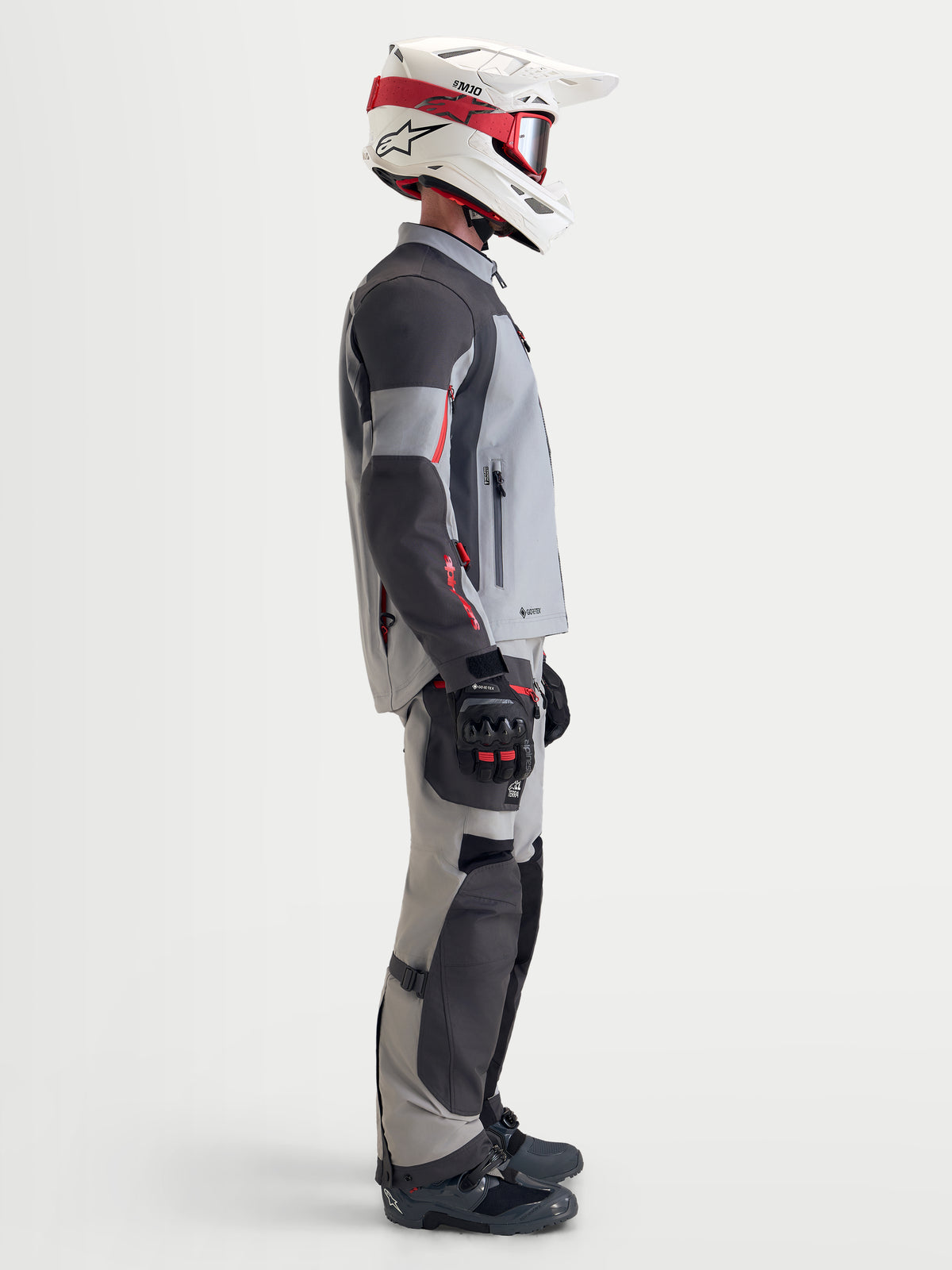 Alpinestars Arenis Gore-Tex Gear Set, Herren-Adventure-Motorradjacke und -hose in Grau und Schwarz, Seitenansicht an einem Model mit passender Ausrüstung und Helm, wasserdichte All-Terrain-Schutzausrüstung