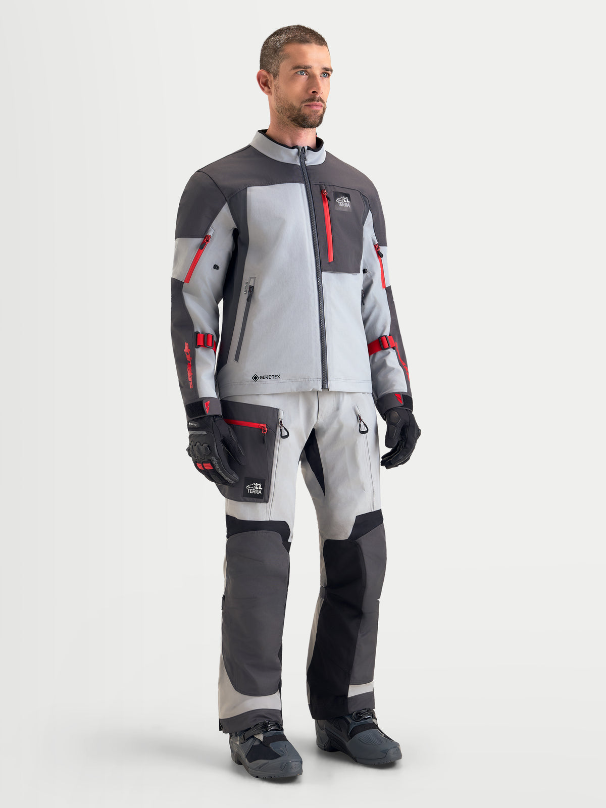 Alpinestars Arenis Gore-Tex Jacket, men's adventure touring motorcycle jacket in mid gray, deep gray, and black, worn by a male model showcasing waterproof textile construction and matching riding gear.