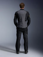Alpinestars ST-7 2L GORE-TEX Jacke, Deep Gray Black und Dark Khaki, Rückansicht an einem Model, Abenteuer-Motorrad-Tourenjacke mit grauer Rückenpartie und schwarzen artikulierten Ärmeln, getragen mit passender schwarzer Hose.