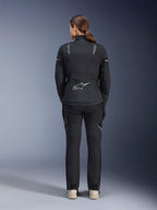 Alpinestars Damen Stella ST-7 2L GORE-TEX Jacke, Schwarz und Dunkelgrau, Rückansicht mit silbernem Alpinestars-Logo am unteren Rücken, kombiniert mit passender schwarzer Textilhose, Adventure-Touring-Motorradausrüstung