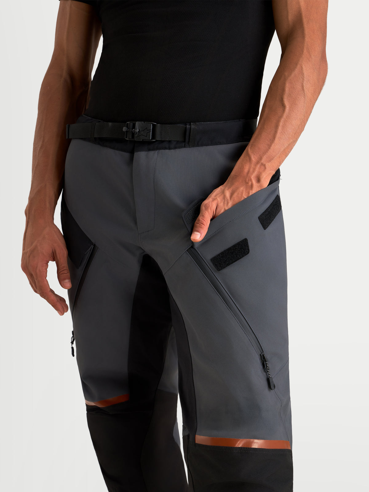 Alpinestars St 7 V 2 2 L Gore Tex Hose, Herren-Adventure-Motorradhose in Dunkelgrau und Schwarz, Nahaufnahme der wasserdichten Textilkonstruktion mit Oberschenkelbelüftung und magnetischem Taillenverschluss am Model