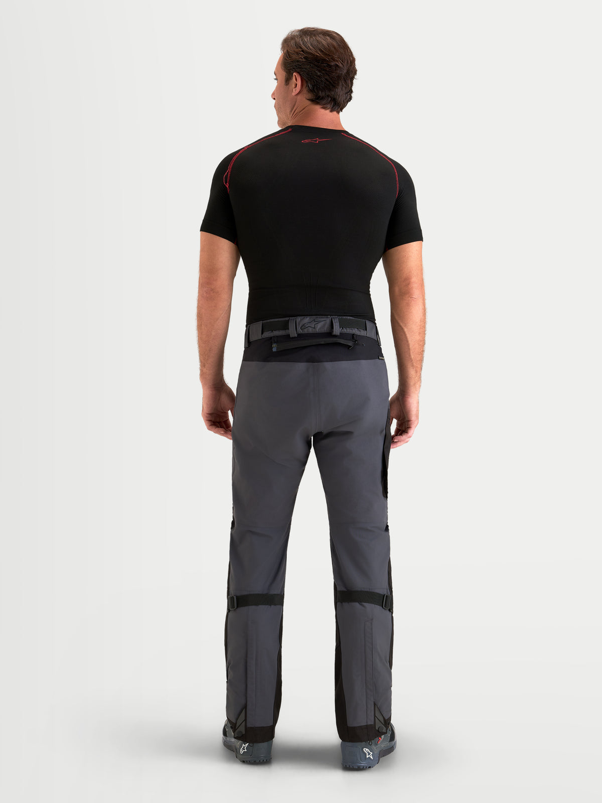 Alpinestars Arenis Gore-Tex Hose, Herren-Adventure-Motorradhose in Schwarz und Dunkelgrau, Rückansicht an einem Model mit wasserdichter Textilkonstruktion und Taillenverschluss