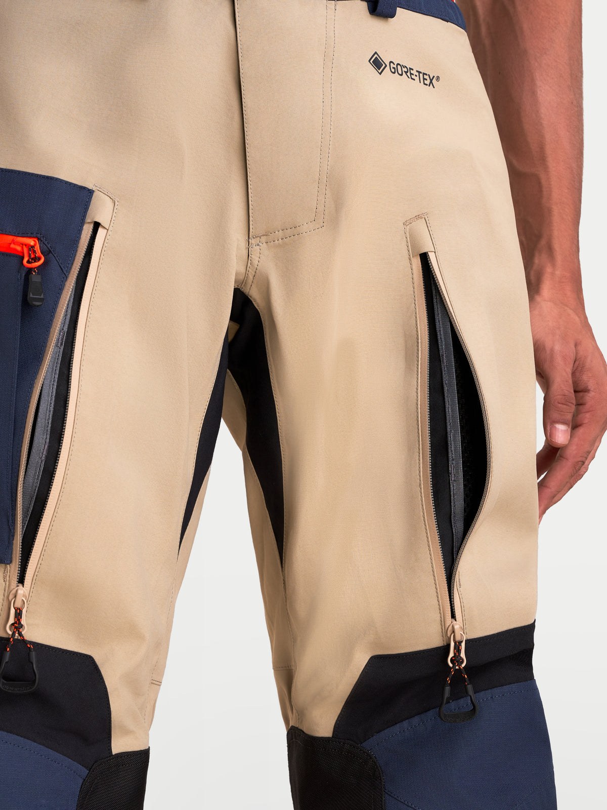 Alpinestars Arenis Gore Tex Hose, Herren-Adventure-Motorradhose, Nahaufnahme der Oberschenkel-Belüftungsreißverschlüsse und des GORE-TEX-Brandings in Beige, Marineblau und Schwarz