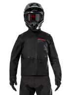 Alpinestars Pro-Dura Jacket, Black Off-road Motorcycle Jacket, front view worn by a rider with a matching black helmet and goggles, featuring red Alpinestars branding, zippered chest pockets, and durable textile construction for enduro riding.