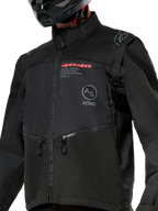 Alpinestars Pro-Dura Jacket, Black off-road motorcycle jacket featuring red Alpinestars branding and a gray circular Astars logo on the chest, zippered hand pockets, and durable ripstop textile construction, rally-inspired design for enduro riding.