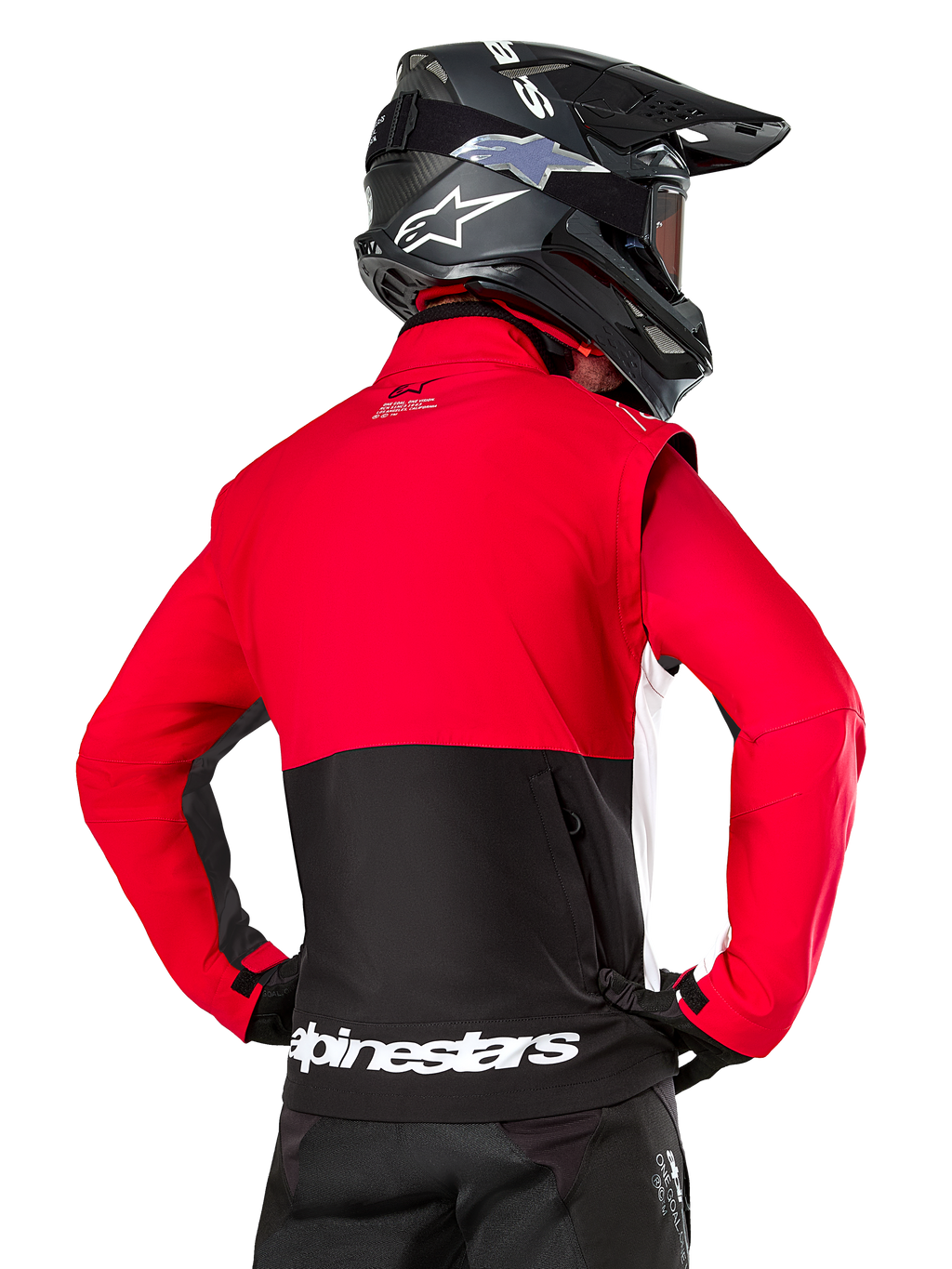 Alpinestars Pro-Dura Jacke, Offroad-Enduro-Jacke, Rot und Schwarz mit weißem Alpinestars-Logo am hinteren Saum, Rückansicht eines Fahrers mit schwarzem Motocross-Helm, Rallye-inspiriertes Design für aggressives Trail-Fahren