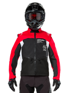Alpinestars Pro-Dura Jacke, Offroad-Motorradjacke, Schwarz, Hellrot und Weiß, getragen von einem Fahrer mit schwarzem Motocross-Helm und Brille, strapazierfähige Ripstop-Konstruktion und weiße Seitenpanels, entwickelt für Enduro- und Trailfahrten