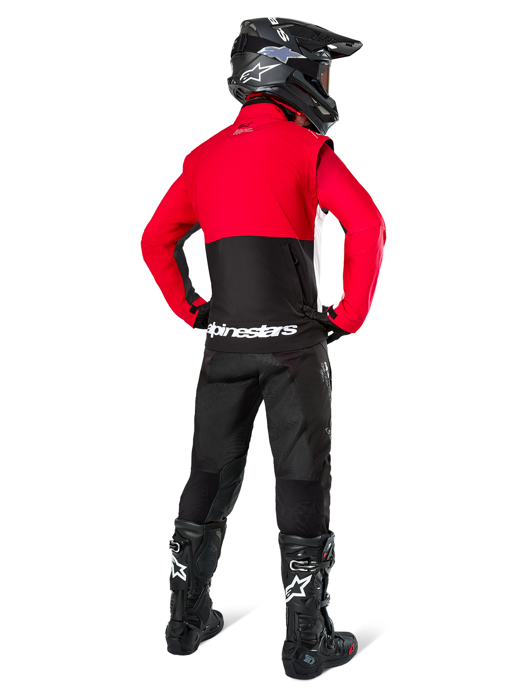 Motocross-Fahrer in der Rückansicht mit der Alpinestars Pro-Dura Jacke in Schwarz, Leuchtend Rot und Weiß, kombiniert mit schwarzer Hose, schwarzem Helm und schwarzen Offroad-Stiefeln, mit rotem oberem und schwarzem unterem Bereich sowie weißem Alpinestars-Branding auf dem Rücken.